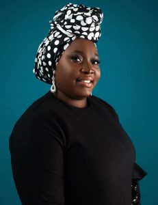 A woman wearing a black shirt and smiling.