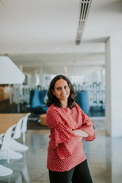 Revathi S. smiling with her arms crossed.