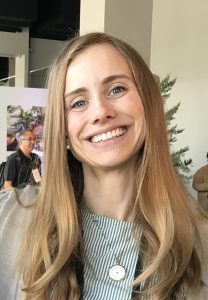 A woman with blonde hair, smiling for the camera