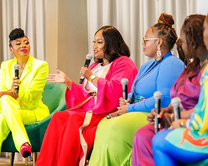 Tiara sitting on a stage with a few other women. 