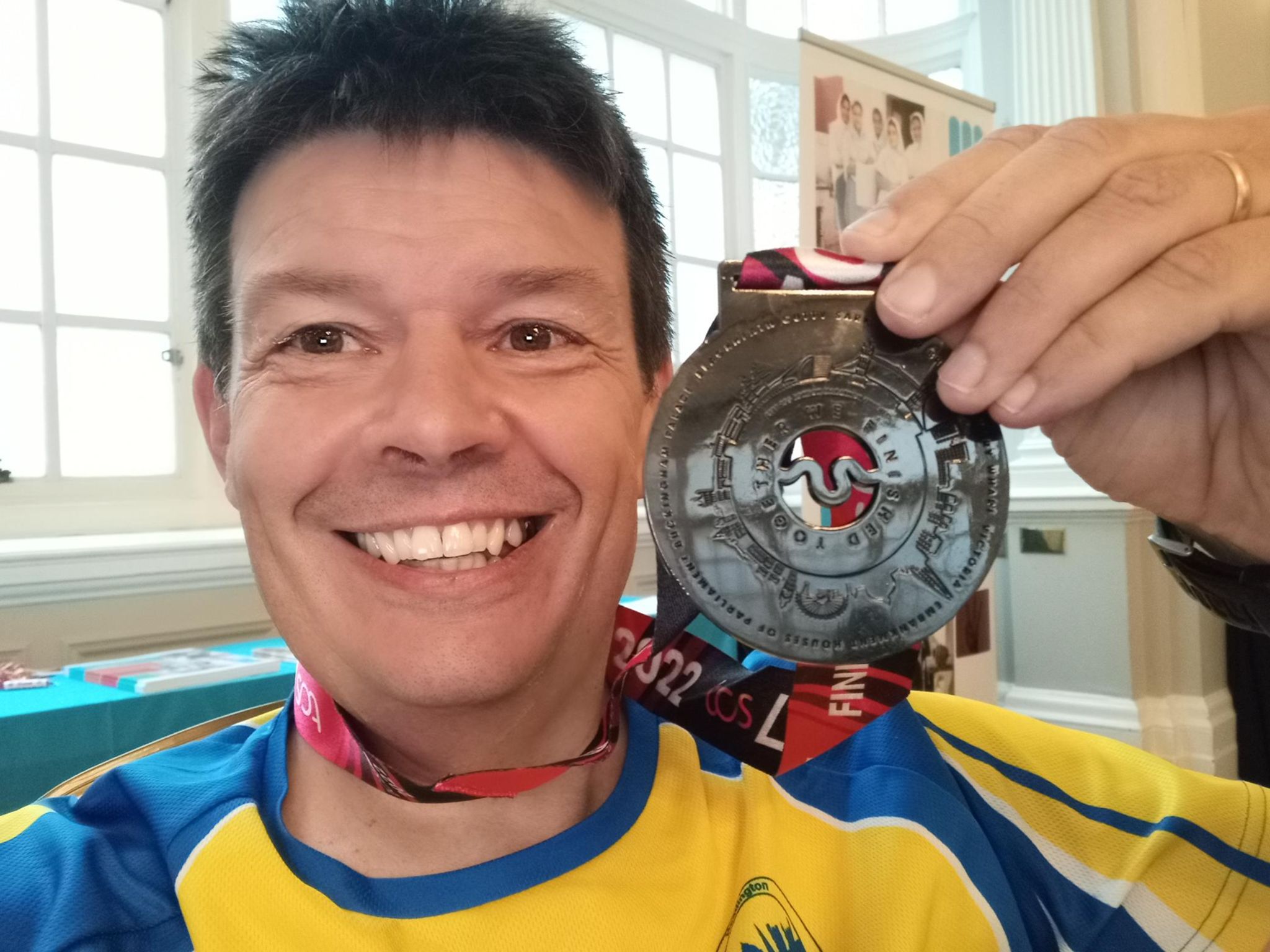 Martin L. holding up a medal and smiling. 