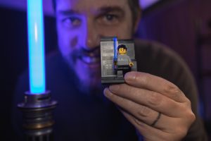 Man holding Lego Star Wars character up to the camera.