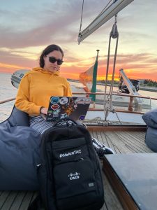 Cisco employee working on laptop on sailboat.