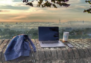 Hoodie, MacBook, and Cisco coffee mug on wall overlooking city of Munich.