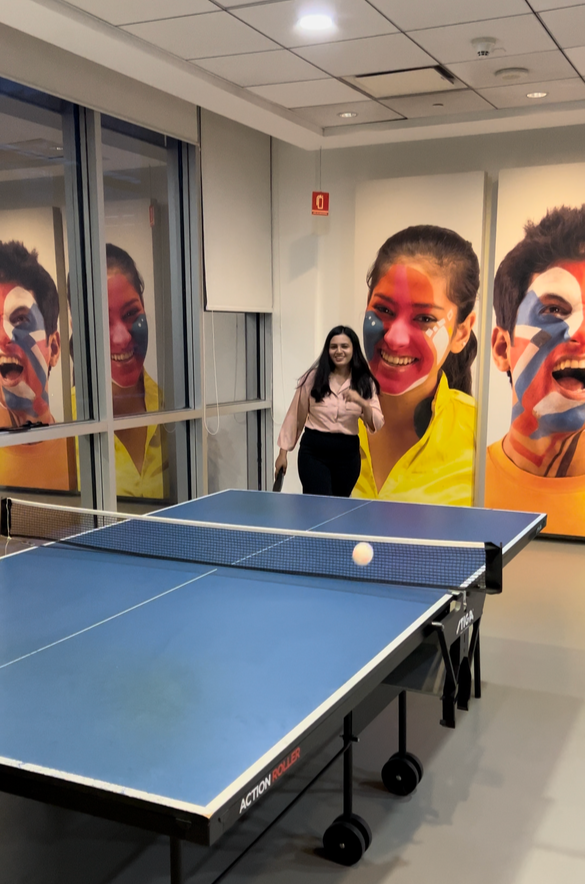 Vaibhavi playing table tennis and smiling. 