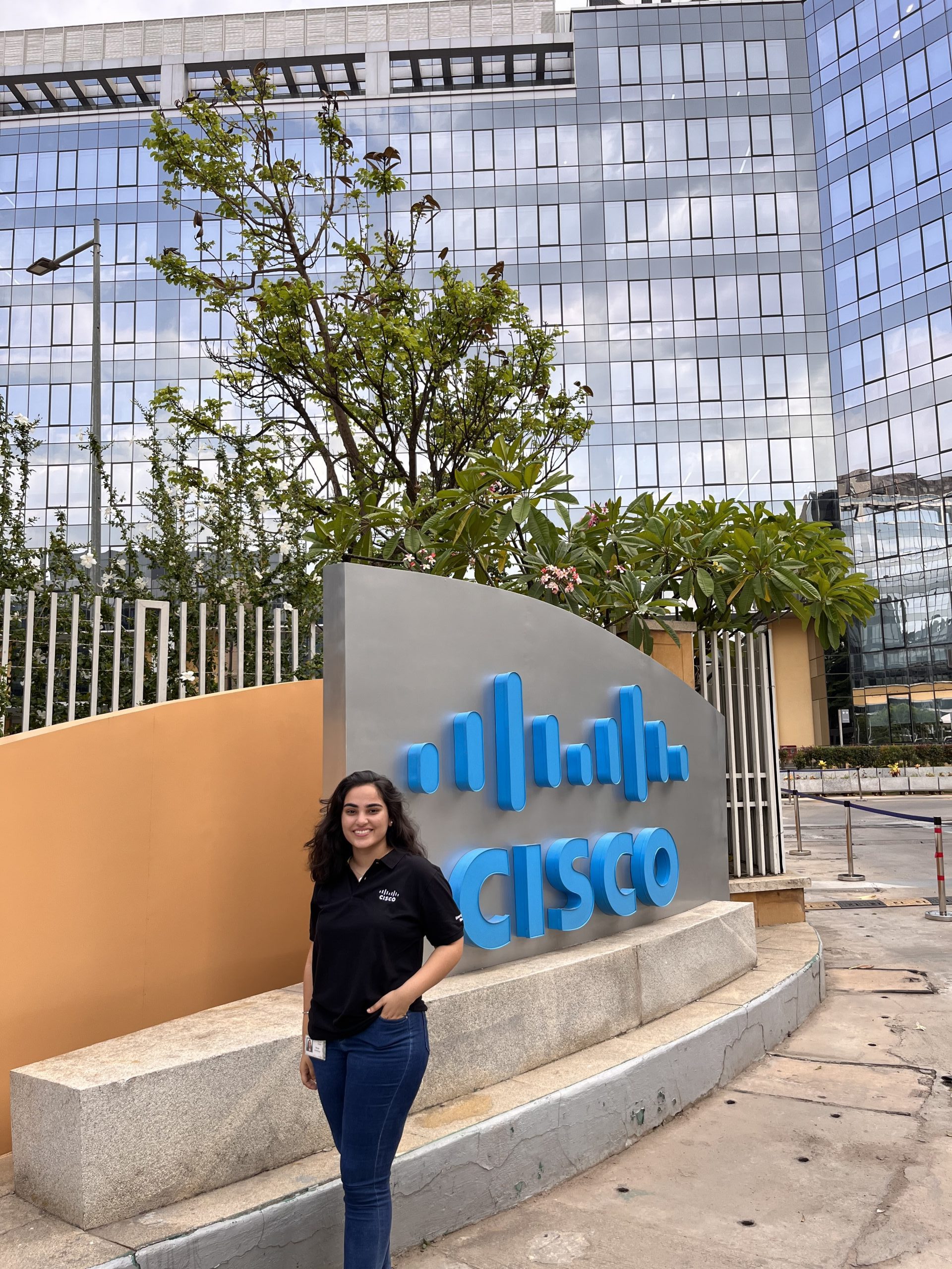 Sanya standing in front of a "Cisco" sign.