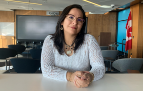 A woman with glasses, looking into the camera