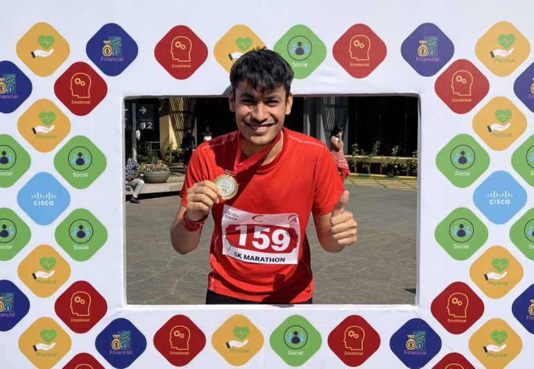 Tanishq holding up a medal.