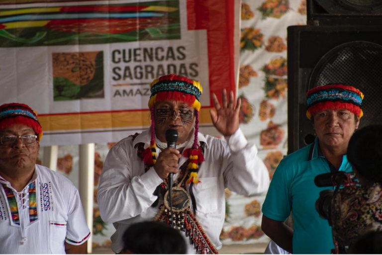 Three men standing together addressing an audience
