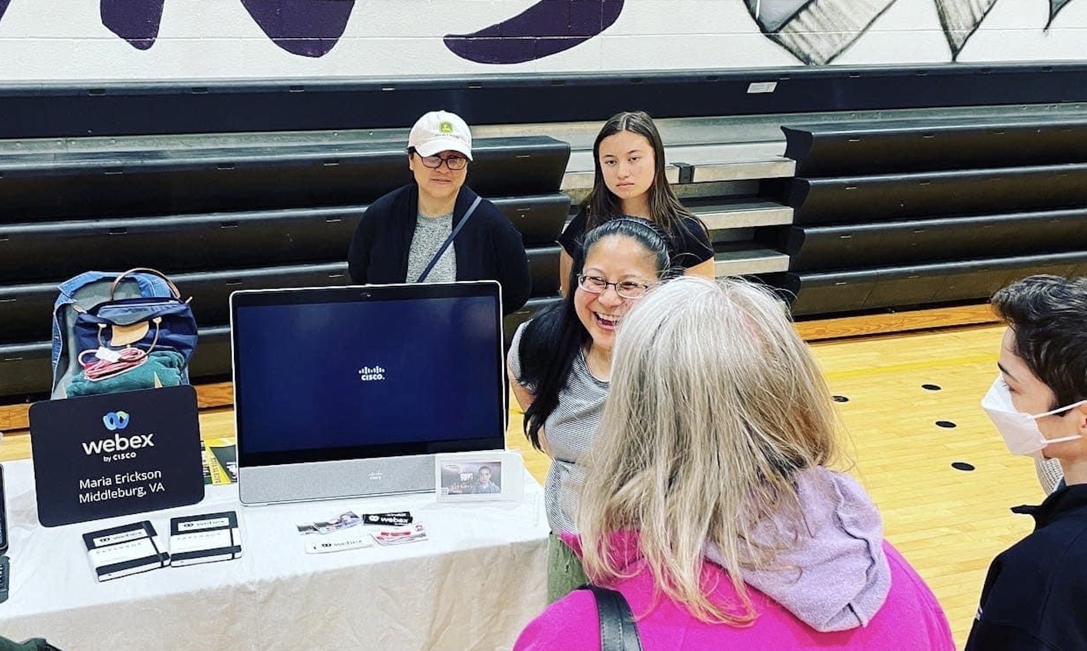 María talking to people at a booth.