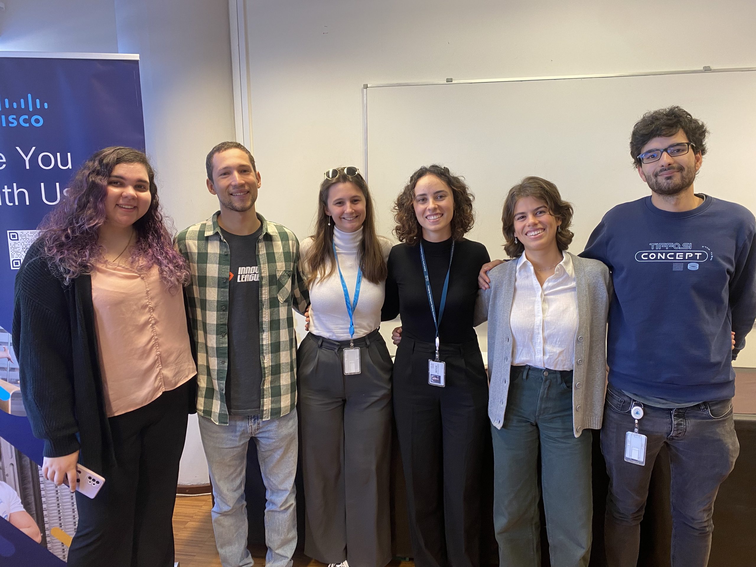 Six people standing together and smiling.