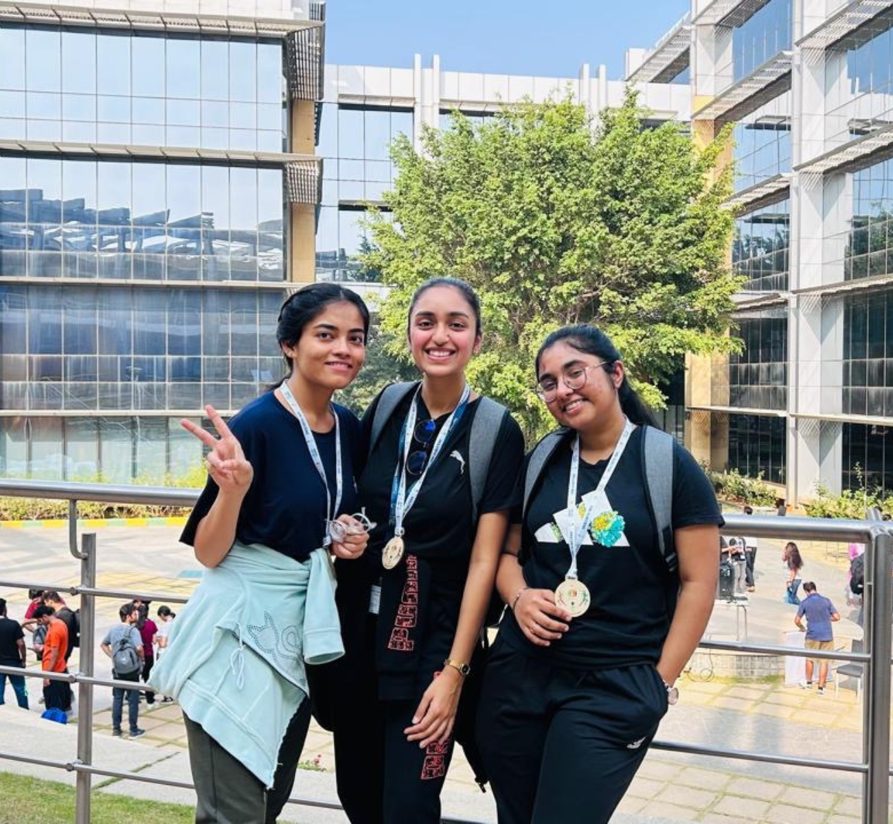 Three people standing together with medals hanging from their necks.