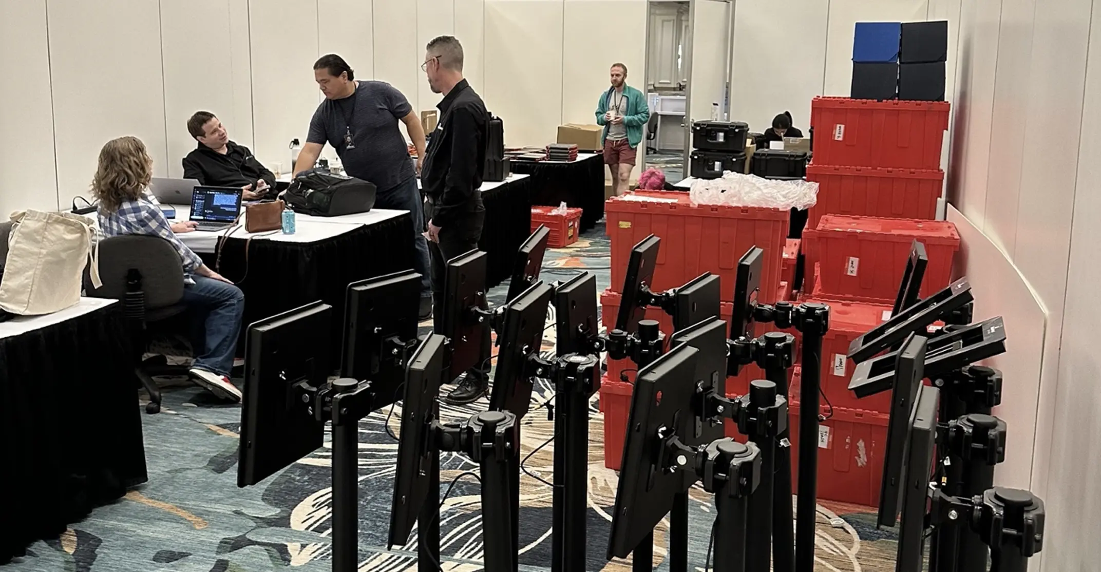 Screenshot of a group of people in a conference room configuring devices