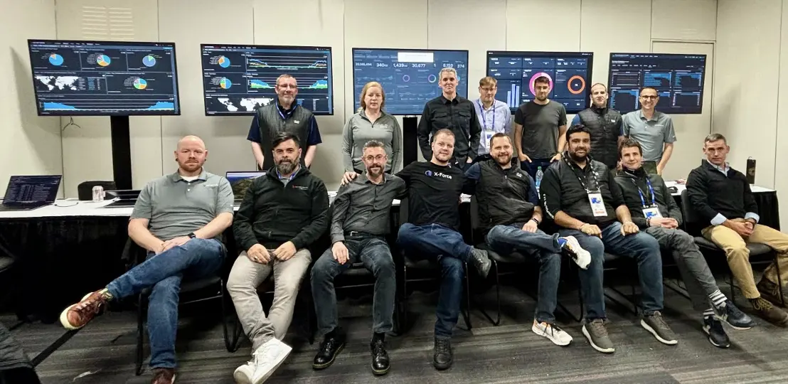 The SOC team, posing in front of computer screens