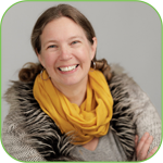 A woman, smiling, wearing a bright yellow scarf