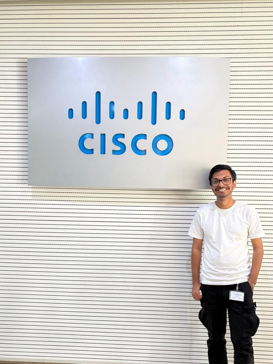 Man standing in front of Silver Cisco sign.