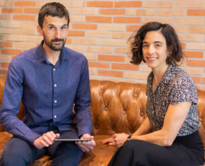 Ersilia co-founders sitting on a couch staring at camera