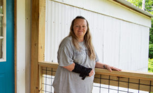 Nurse Teresa standing outside her home that was affected by Hurricane Helene