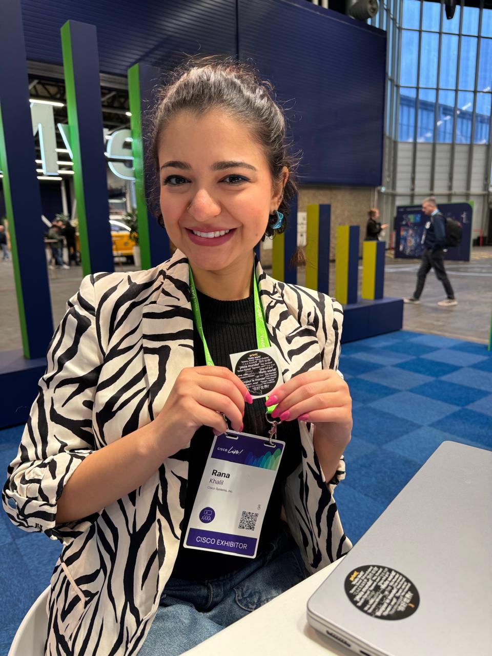 Woman smiling holding her Cisco badge.
