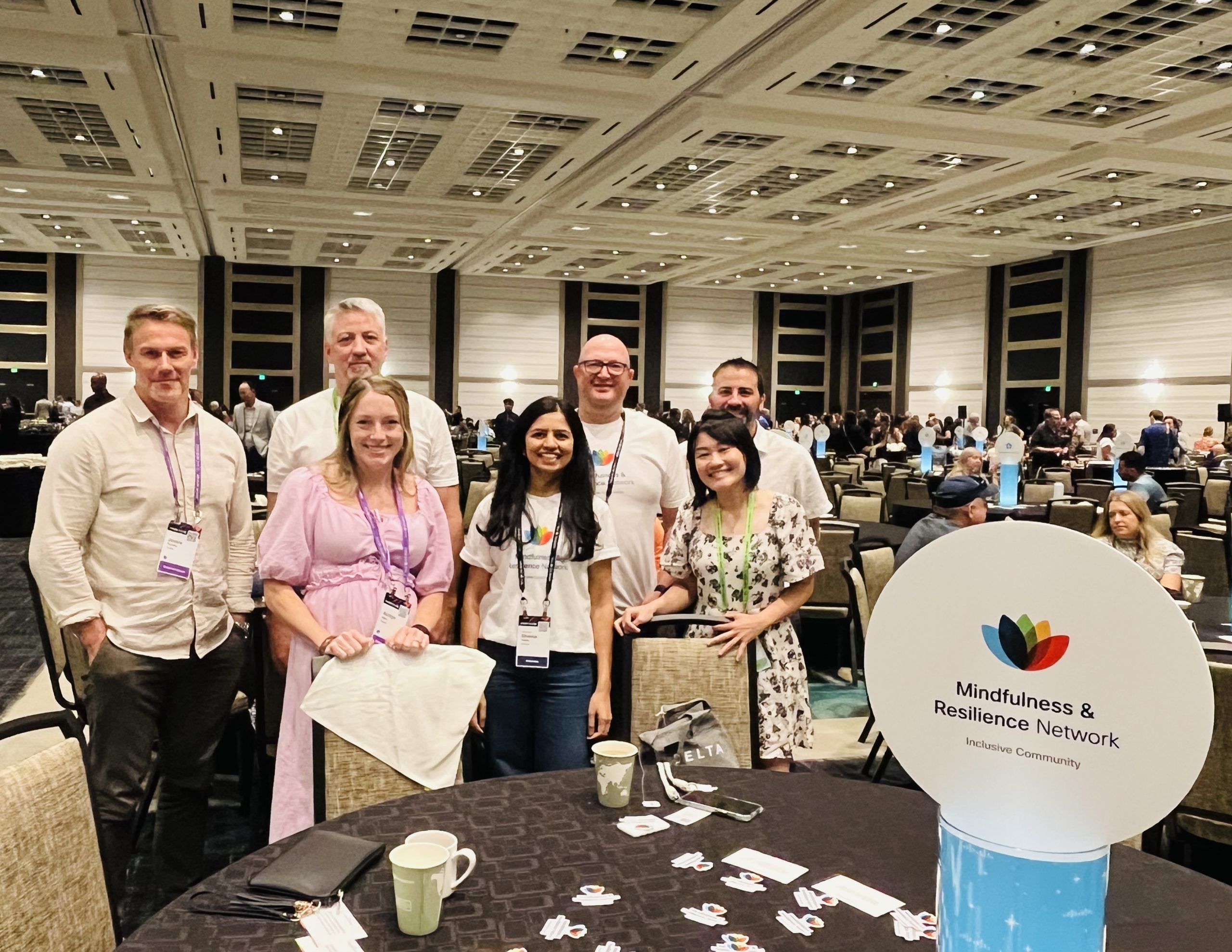 Group gathered around the table with the Cisco Mindfulness Logo on the table.