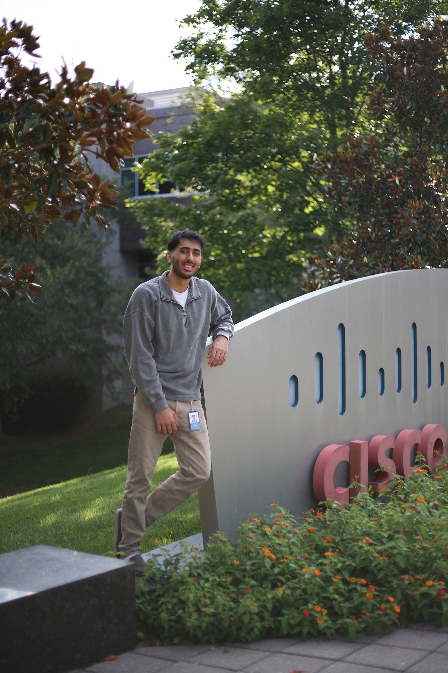 Man standing against a Cisco office sign outside.