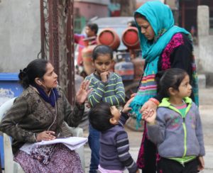 Worker helping a mother with three small children