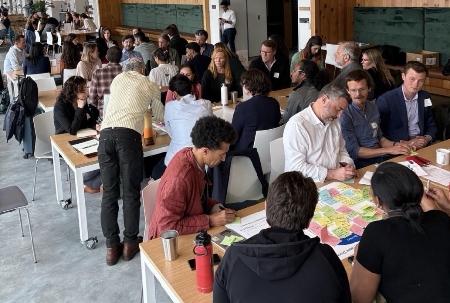 Several people sitting at long tables in a room.