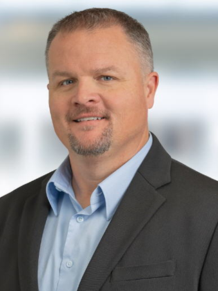 A man wearing a blue shirt and dark blazer