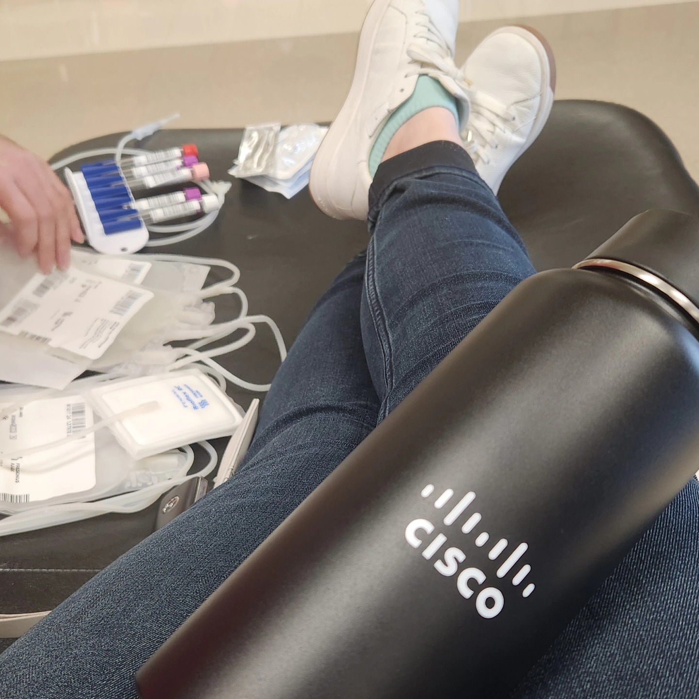 Picture of woman's lap top and Cisco water bottle laying on her lap.