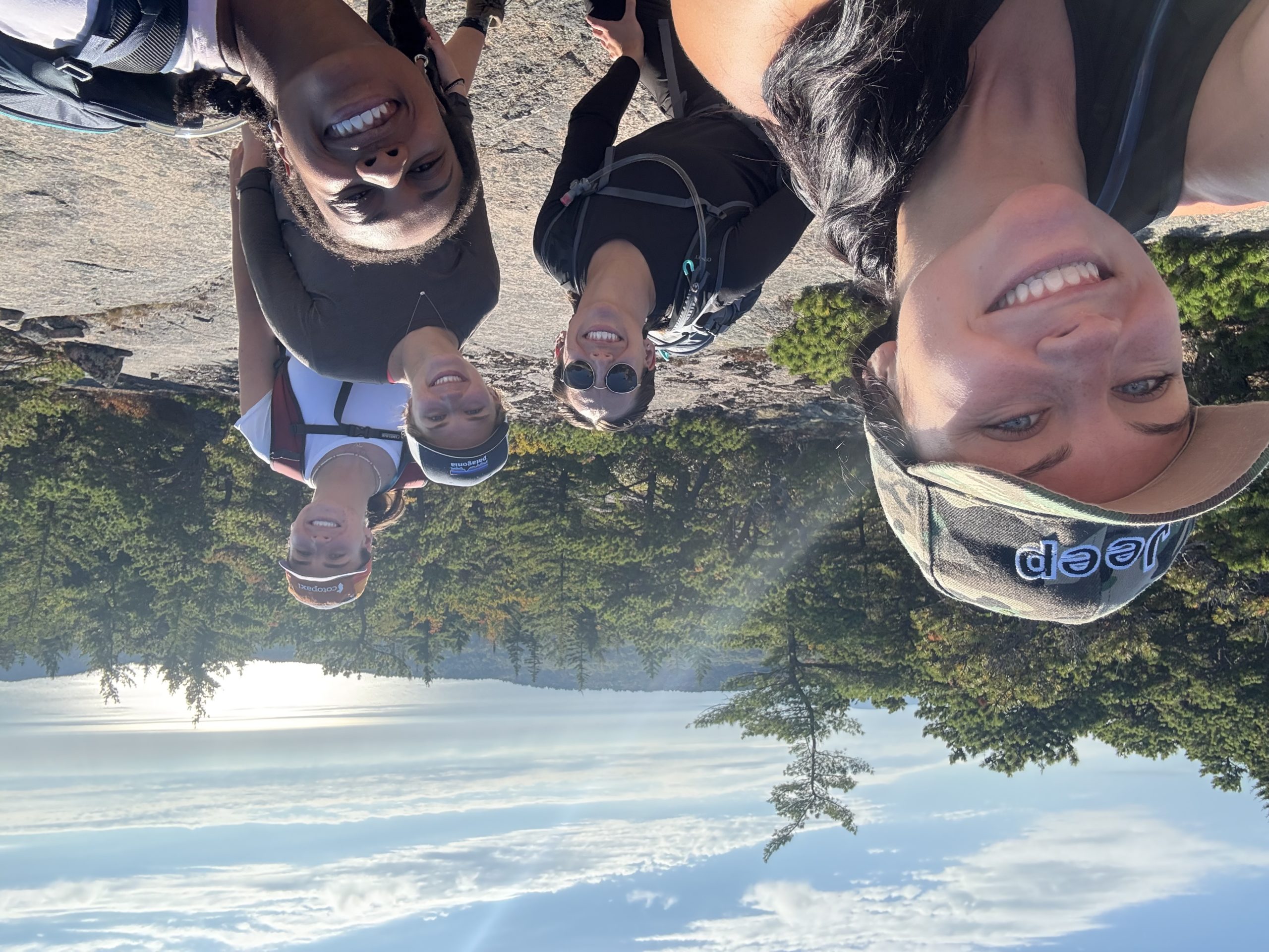 Five women posing on a trail smiling.