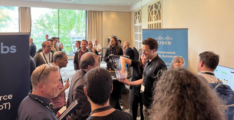 A crowd of engineers gather to hear another engineer explain something in the LEarn with Cisco booth