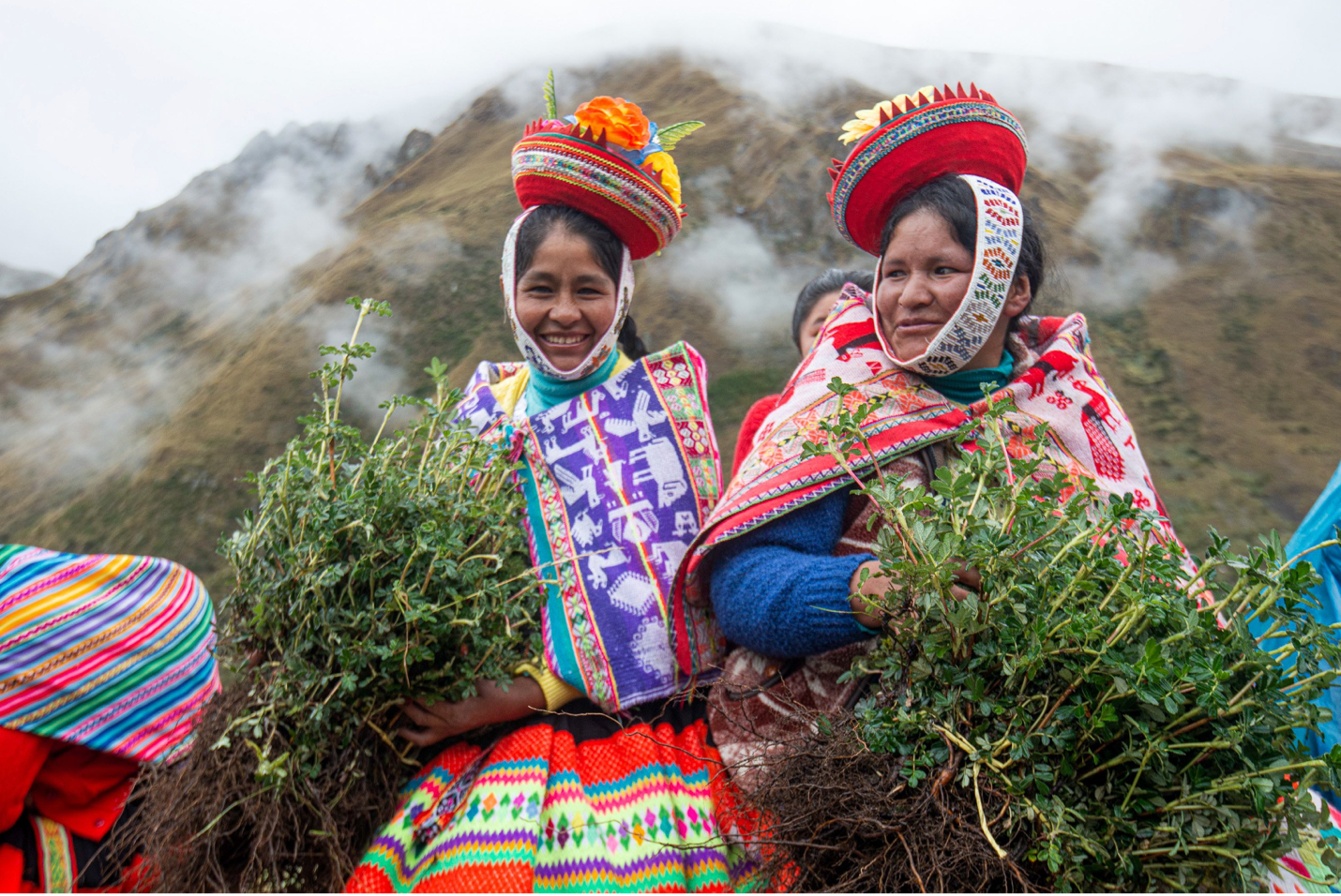 Farmers in a mountain setting, wearing colorful clothes.
