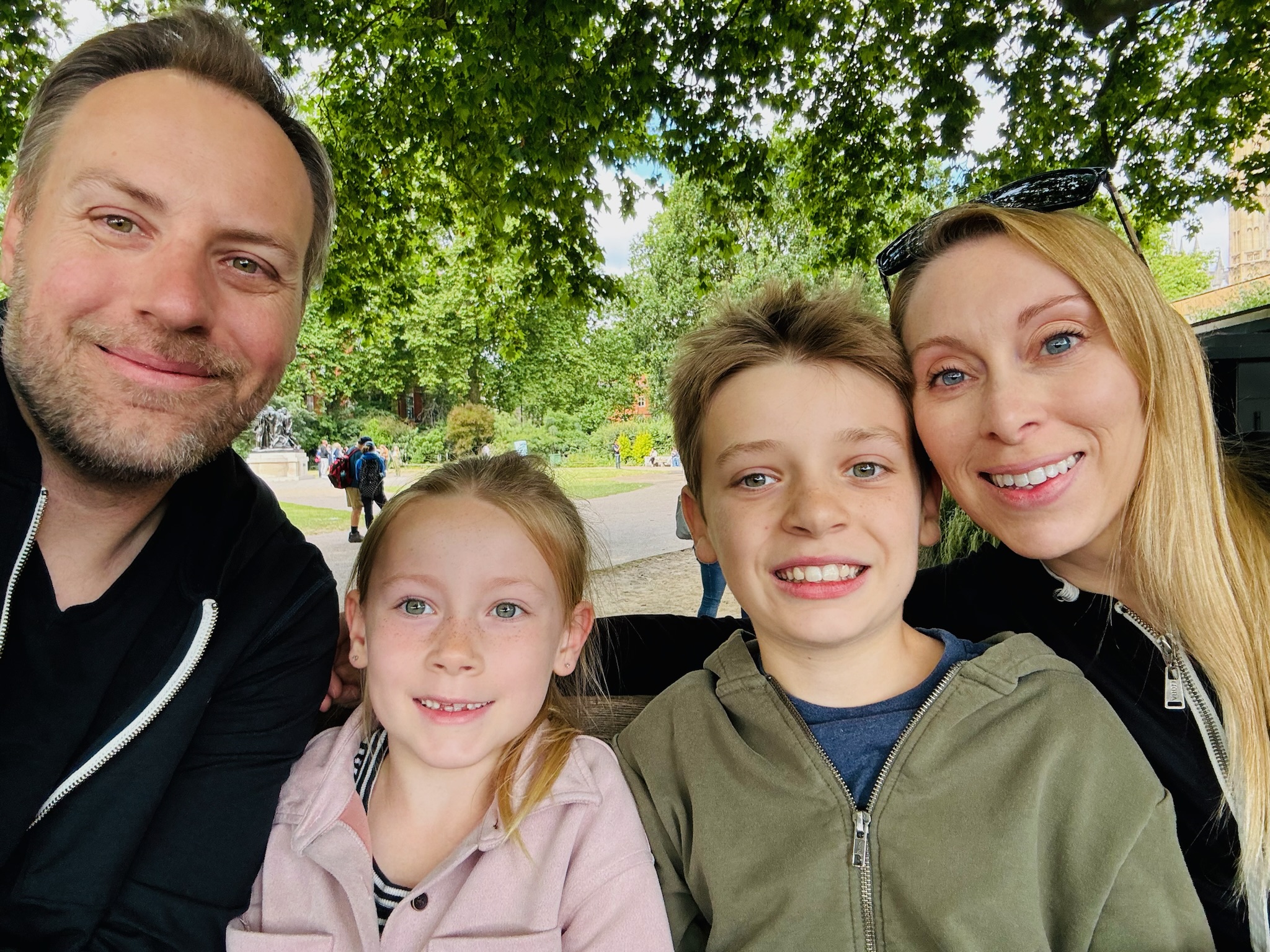 A family of four, smiling at the camera.