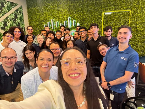 Selfie d’un groupe de personnes devant une pancarte Cisco.