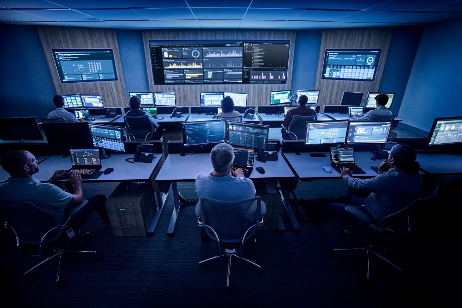 Image of employees looking at computer screens in a room 