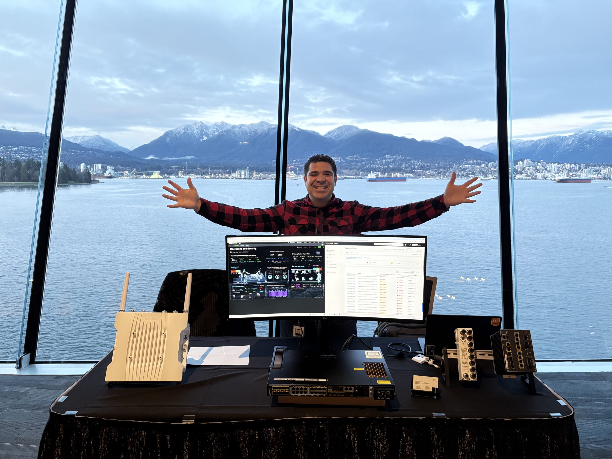 Standing behind a networking demo booth with a waterfront mountain view.*