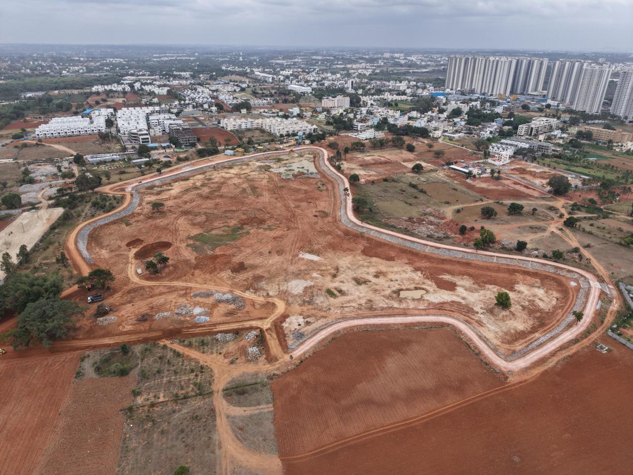 An aerial drone image of a lakebed under construction, surrounded by buildings.
