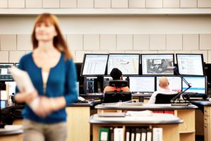 Woman in front of computer monitors. 