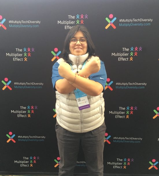 Roxana posing in front of a backdrop for #MultiplyTechDiversity.