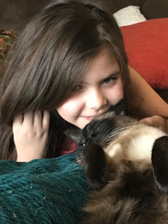 Helene laying with the family cat, Cookie.