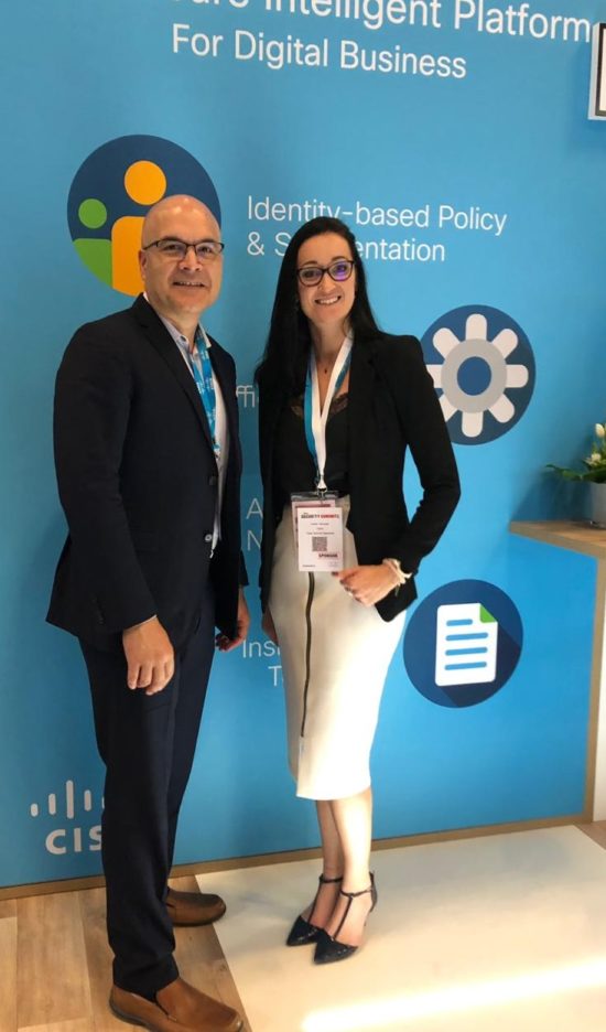 Corein stands with a peer in front of a Cisco sign.