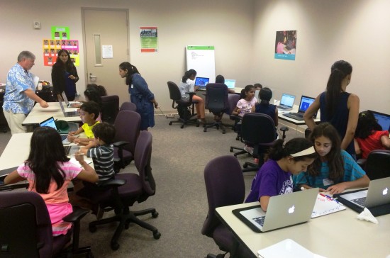 Teacher Brian VanDyck and Embark Labs Founder Jessie Arora watch as the students work on their coding projects