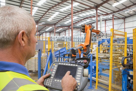 11 Feb 2013 --- Worker operating robotic machinery in factory --- Image by © Ian Lishman/Juice Images/Corbis